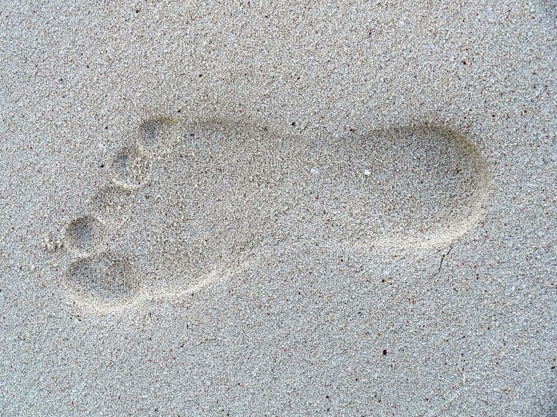 footprints in the sand tattoo on feet